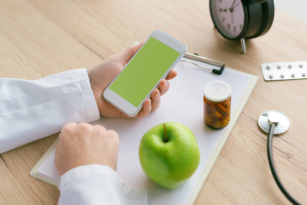 Doctor advising apple instead of pills and antibiotics - Foto, Imagem
