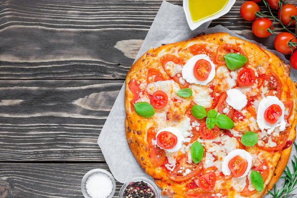 Włoska pizza Margherita z roztopionym mozzarellą, pomidorami i świeżą bazylią - Zdjęcie, obraz