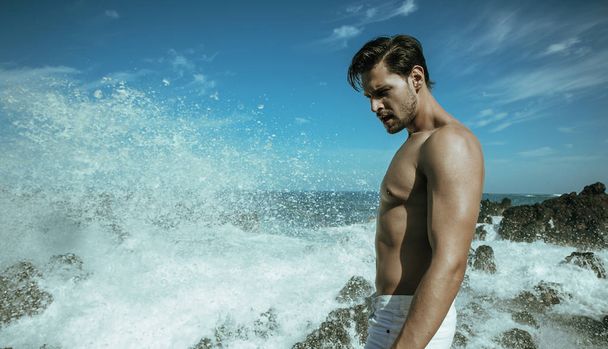 Handsome, muscular man posing on the seaside - Foto, afbeelding