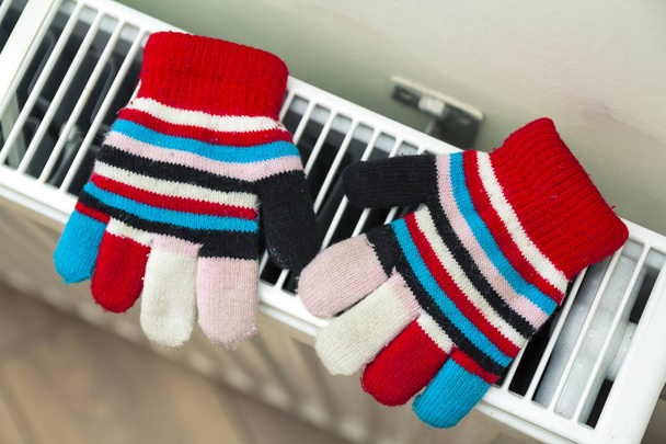 Παιδική ζεστό χέρι πλεκτό ριγέ μάλλινα γάντια ξήρανση σε hea - Φωτογραφία, εικόνα