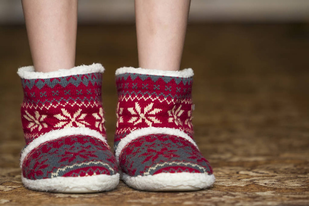 nackte Kinderbeine und -füße in roten Winter-Weihnachtsstiefeln mit Orna - Foto, Bild