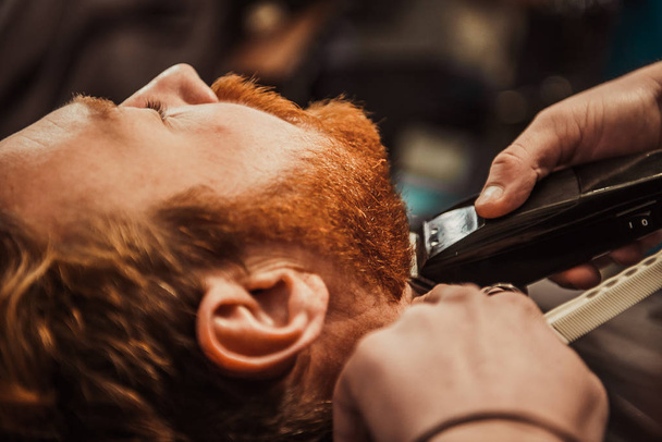 Profesjonalny fryzjer obcina brodę klientowi. Fryzjer - Zdjęcie, obraz