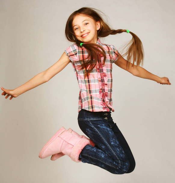 girl jumps on a gray background - Фото, изображение