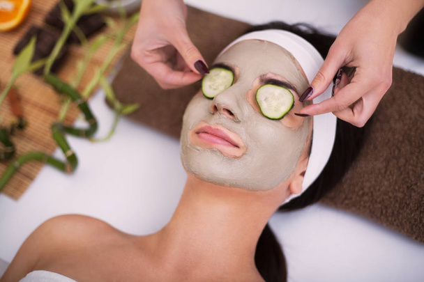 Spa. Beautiful young woman is getting facial clay mask at spa, l - Фото, зображення