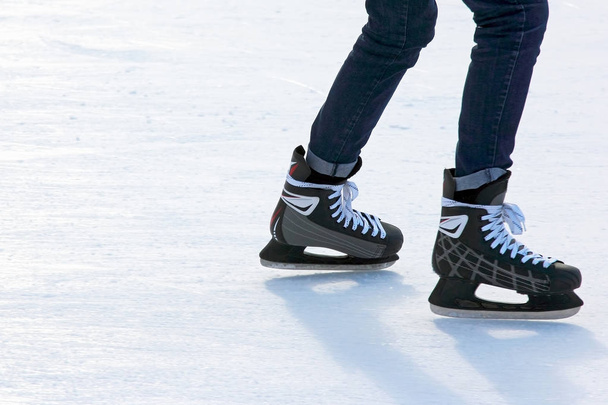 feet on the skates of a person rolling on the ice rink - Fotoğraf, Görsel