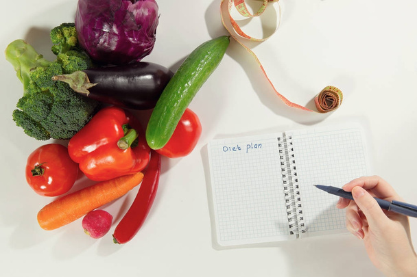 Female nutritionist hand writing diet plan - Фото, изображение