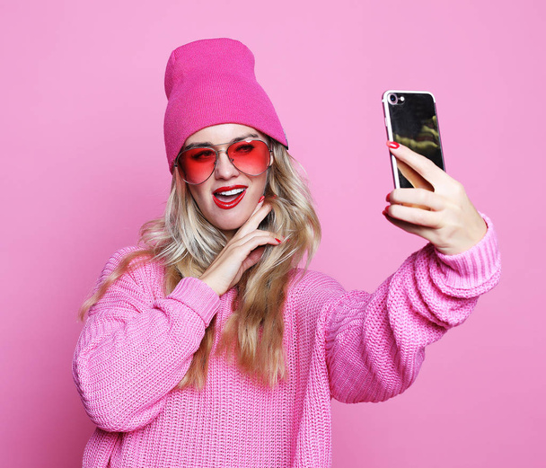 Fashion girl  taking photo makes self portrait on smartphone wea - Фото, зображення