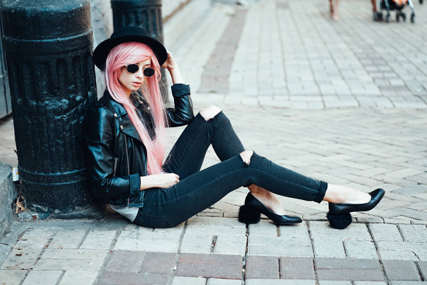 girl with pink hair posing on city street - Foto, Imagen