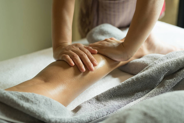 Aromatherapy massage series: Therapist massaging Asian woman leg - Foto, Imagen