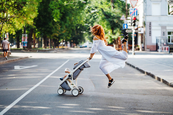 mom with a stroller crosses the road - Foto, imagen