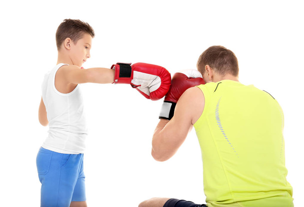 Cute little boy training with boxing coach, on white background - Fotó, kép