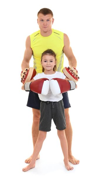 Cute little girl with boxing coach on white background - Фото, изображение