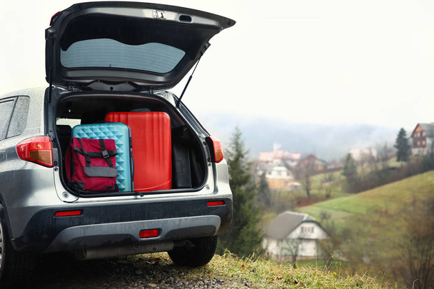 Car with luggage in countryside - 写真・画像