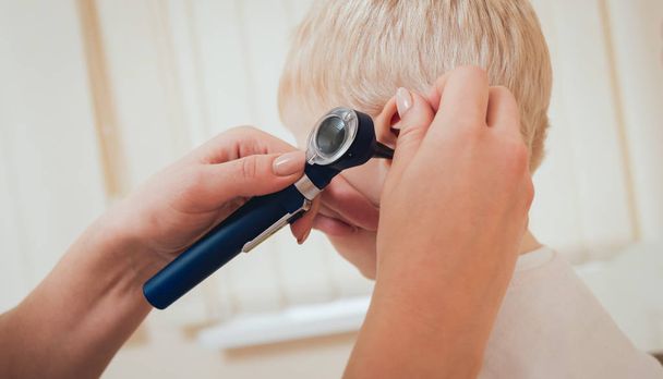 Doctor examines ear with otoscope in a pediatrician room. Medical equipment - Fotoğraf, Görsel
