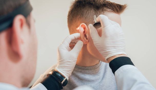 Doctor examines boy ear with otoscope. Medical equipment - Foto, Imagem