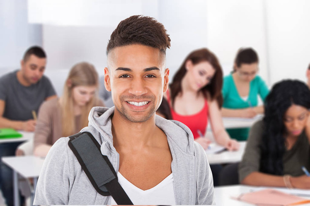 Porträt eines lächelnden männlichen Studenten im Klassenzimmer - Foto, Bild