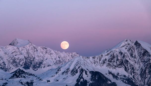 plný měsíc vychází nad zimní horské krajiny v švýcarských Alpách - Fotografie, Obrázek