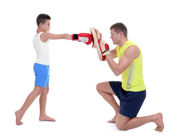 Cute little boy training with boxing coach, on white background - Фото, изображение