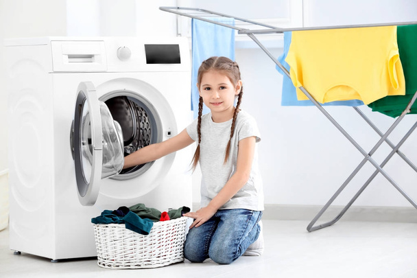 Cute little girl doing laundry at home - Foto, Imagem