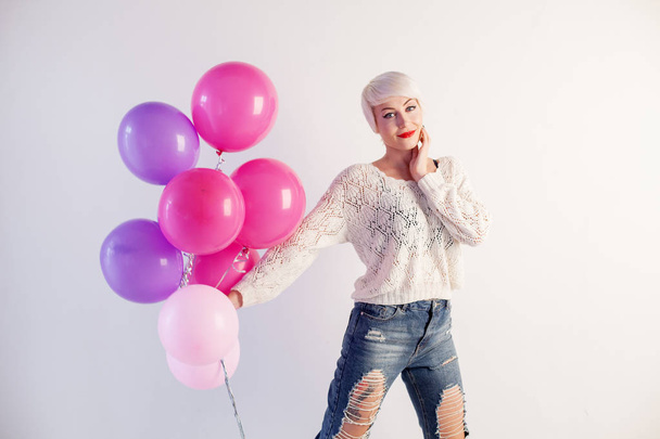 blonde girl with balloons and gift on a holiday - Foto, imagen