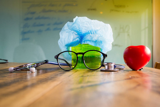 Stethoscope, beaker, glasses, medical cap and heart. - Photo, Image