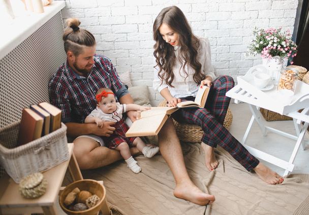 Gelukkig jonge familie moeder, vader en dochter spelen op tapijt thuis. - Foto, afbeelding