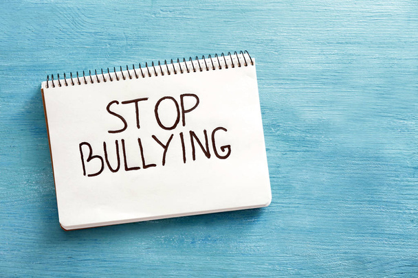 Notebook with text "Stop bullying" on color background, top view - Fotografie, Obrázek