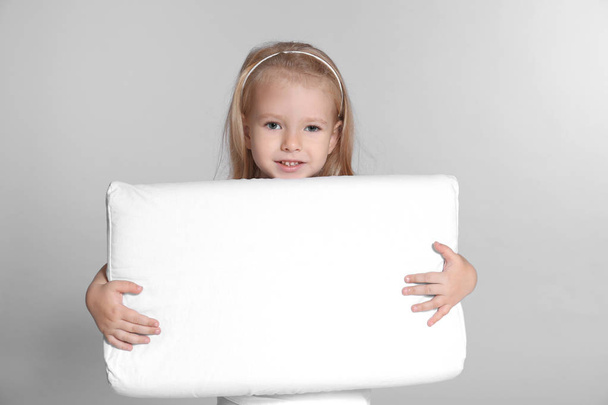 Little girl with big pillow on grey background - Foto, Imagen
