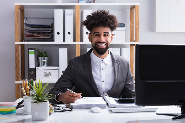 Portrait Of A Young Happy Businessman Working In Office - Fotografie, Obrázek