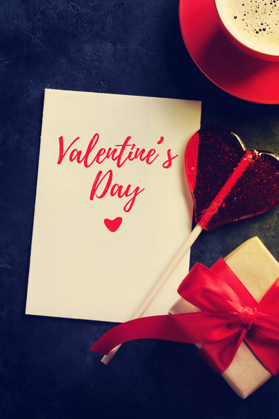 Valentin-nap-üdvözlőlap, candy szív, kávéscsésze és ajándék doboz a kő asztal. Szemközti nézet másol hely - Fotó, kép