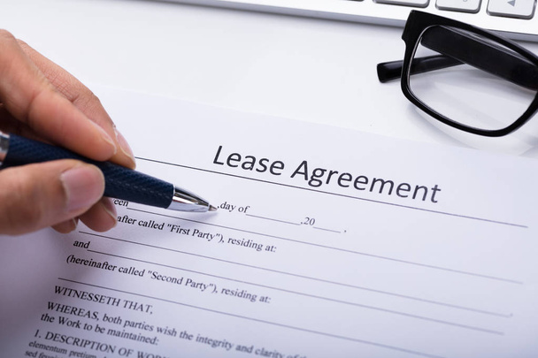 Close-up Of A Person's Hand Filling Lease Agreement Form - Foto, immagini