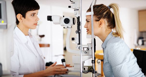 Optometrist examining patient in modern ophthalmology clinic - Foto, immagini