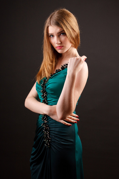 Studio portrait of a beautiful young woman in green dress - Фото, изображение
