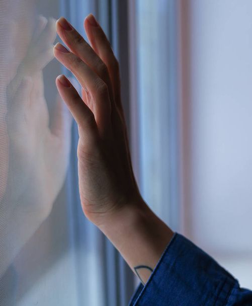 Die Hand der Frau berührt das Fenster - Foto, Bild