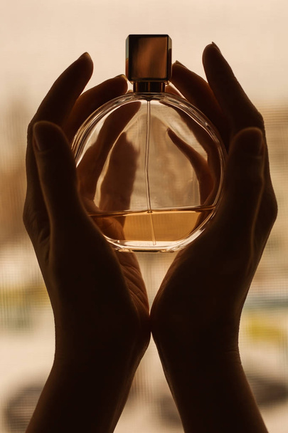 Kobiece ręce trzymając butelkę perfum  - Zdjęcie, obraz