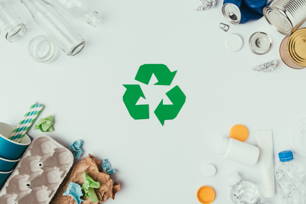 flat lay with arranged different types of garbage and recycle sign isolated on grey - Photo, Image