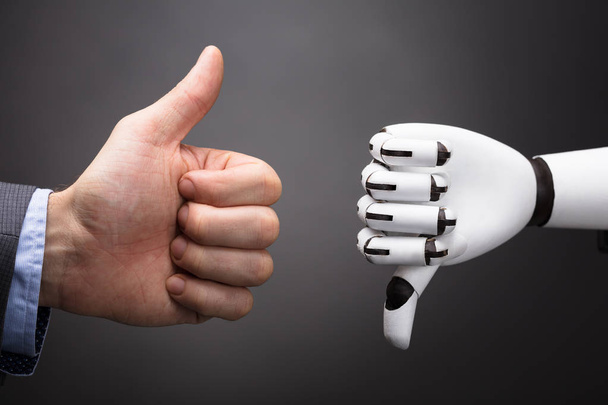 Businessperson And Robot Showing Thumb Up And Thumb Down Sign On Grey Background - 写真・画像