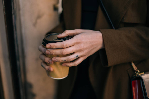cropped view of woman in coat holding takeaway cup with coffee to go - Zdjęcie, obraz