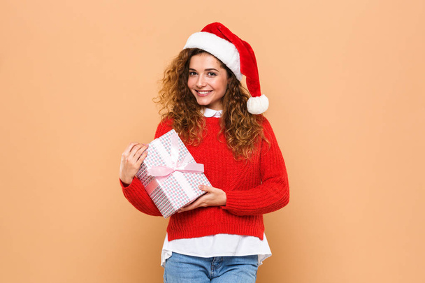 Portrait of a smiling cheery girl dressed in santa hat - Foto, afbeelding