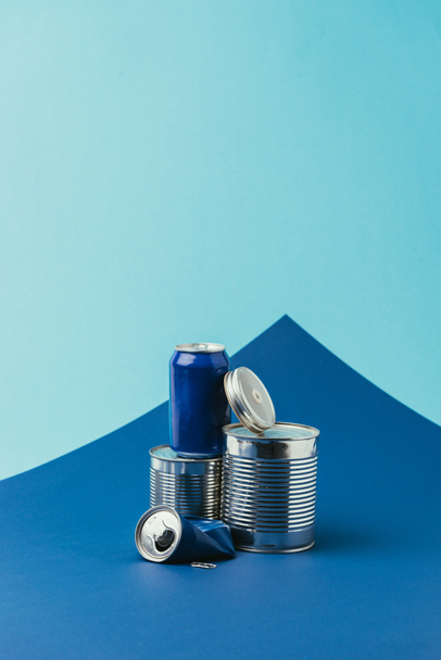 close up view of arranged metal cans on blue background, recycle concept - Fotografie, Obrázek