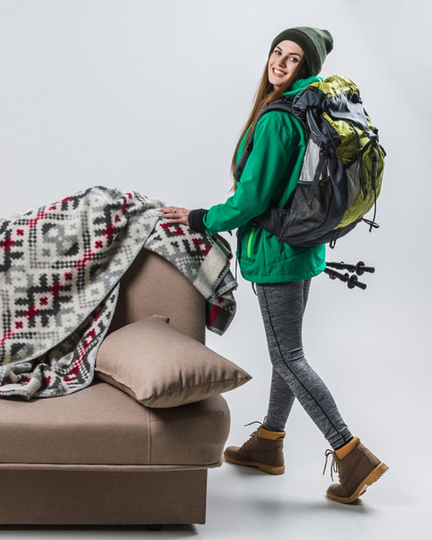 beautiful femele hiker with backpack at sofa with plaid - Photo, Image