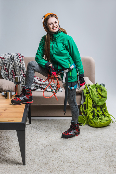 belo alpinista sorridente no capacete com equipamento de escalada em casa
 - Foto, Imagem