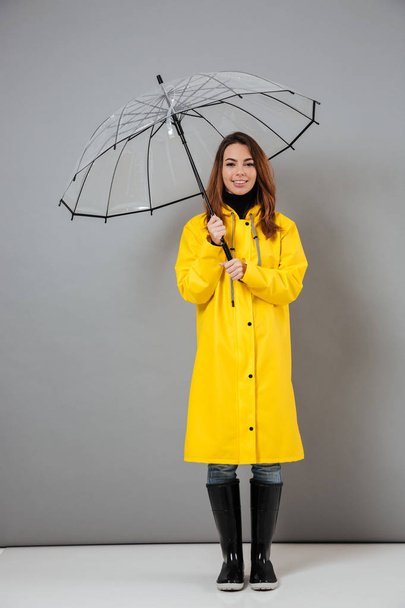 Full length portrait of a pretty girl dressed in raincoat - Photo, image
