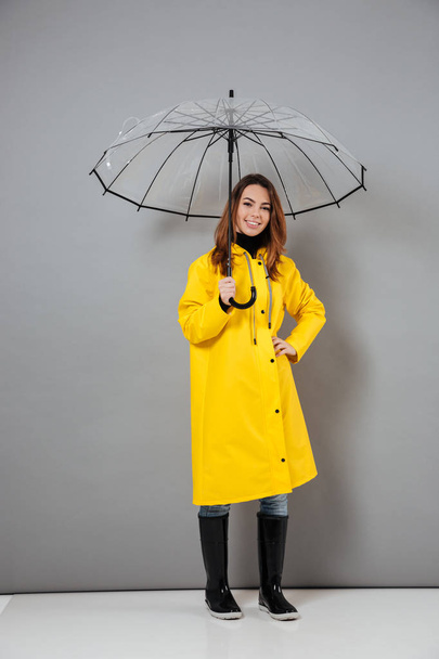 Teljes hossza portré egy vidám lány öltözött esőkabát - Fotó, kép