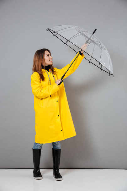 Full length portrait of a smiling girl dressed in raincoat - Fotoğraf, Görsel