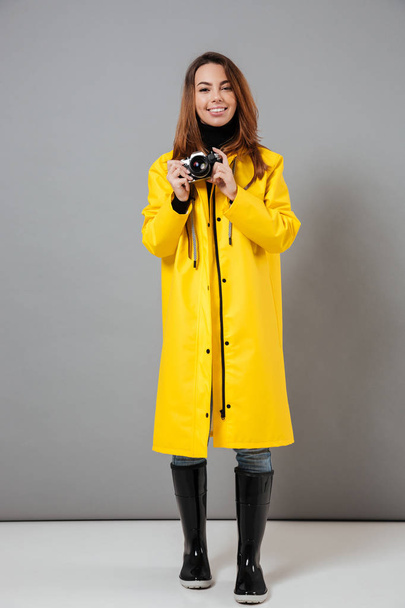 Full length portrait of a happy girl dressed in raincoat - Фото, зображення