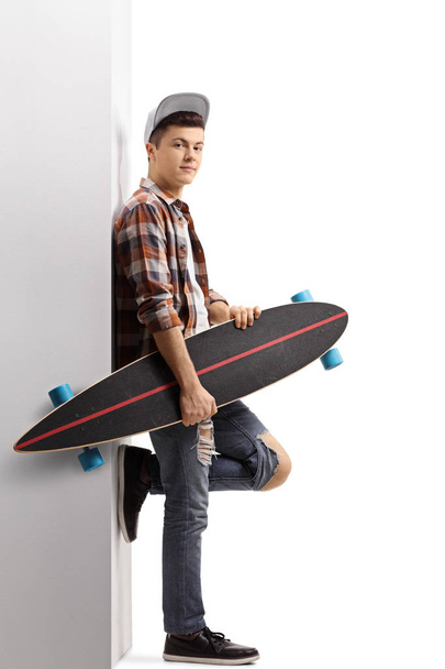 Teenage hipster holding a longboard  - Foto, afbeelding
