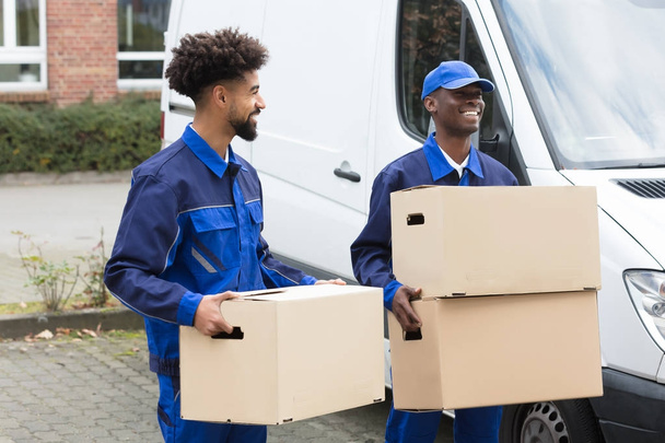 Close-up Of Two Delivery Men Holding The Cardboard Boxes - Foto, Bild
