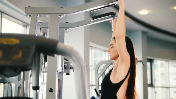 Spor salonunda omuzlar için eğitim - egzersiz çekici genç kadın - Video, Çekim