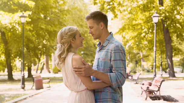 Loving couple gently embracing, enjoying long-awaited date in park, first love - Foto, Imagen